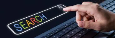 A finger pressing the search icon on a keyboard, illustrating keyword research to avoid duplicate content.