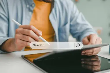 Person using a stylus on a tablet to interact with a search bar, highlighting the concept of targeted search for Featured Snippet opportunities.
