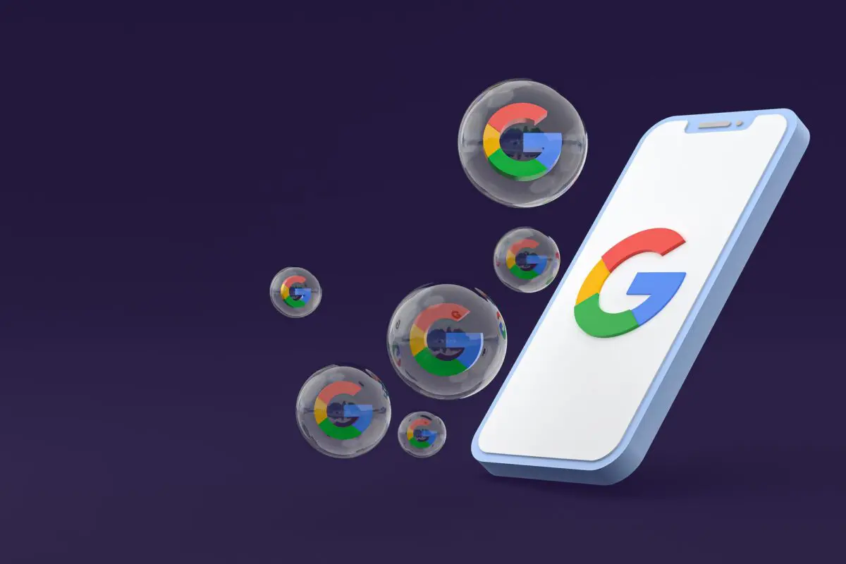 Smartphone with a Google logo on the screen and floating bubbles containing the logo on a dark purple background.
