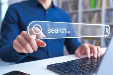 A person uses a virtual search bar to find a direct answer on a laptop.