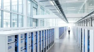 Man walks through a modern data center, symbolizing Sheryl Sandberg's role in building Facebook's infrastructure.