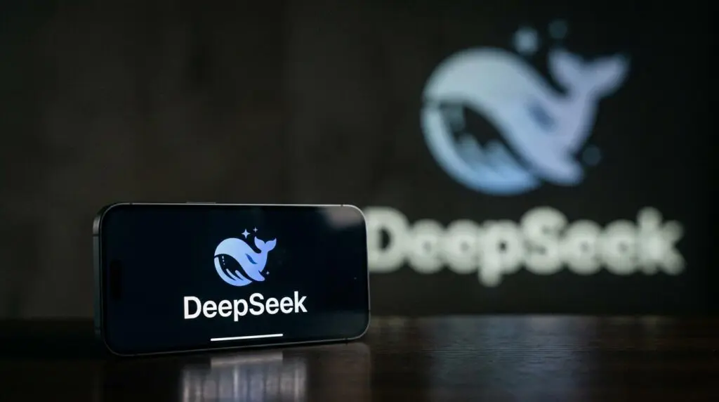 Smartphone with DeepSeek app logo and wordmark, blurred projection, symbolizing funding freeze after founder's remarks.