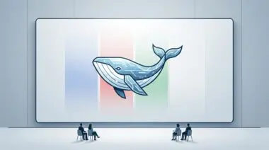 Tech presentation screen showing a circuit-style whale logo to an audience in an auditorium.