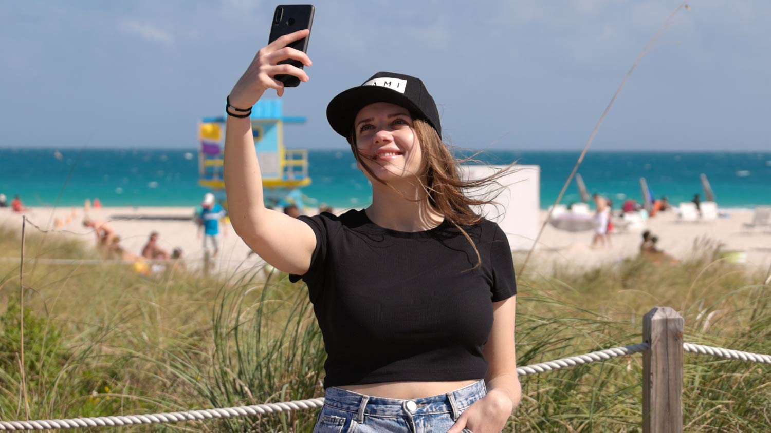 Beautiful woman in Miami Beach takes a selfie on the beach